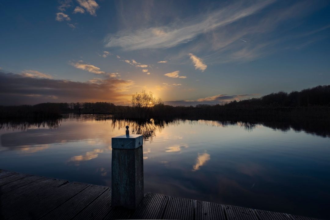 Foto van ondergaande zon gemaakt vanaf een steiger